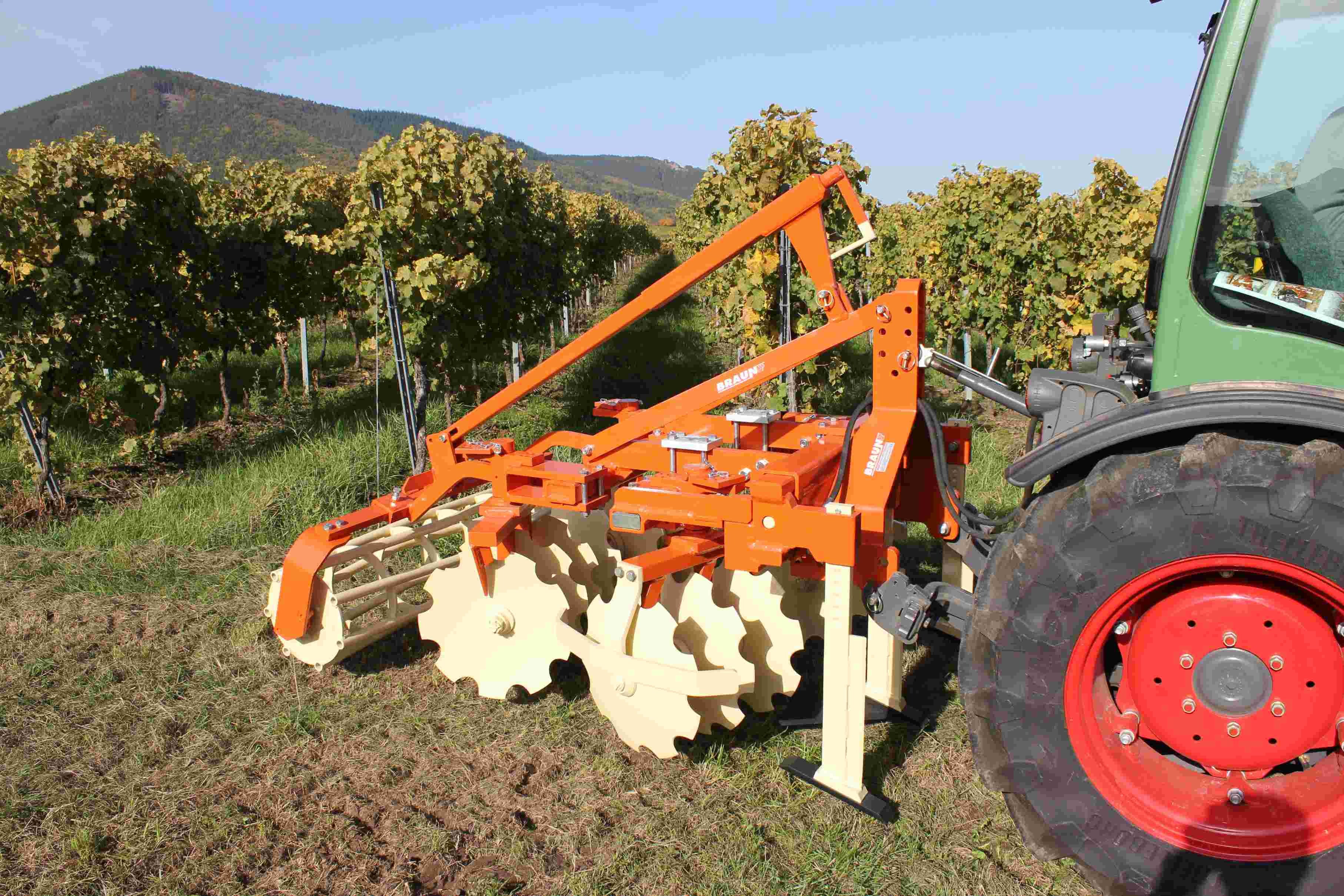 Kultivátor BRAUN Vario připojený za traktor při práci